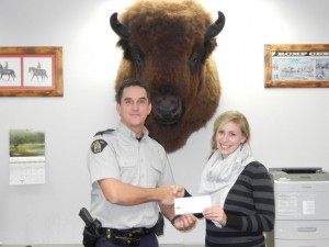 Trail Detachment Commander Sgt. Darren Oelke accepts the cheque from Laura Laratta of the Le Roi Foundation. The LeRoi Foundation graciously donated a $1500 grant to the Trail keepin' it REAL program.